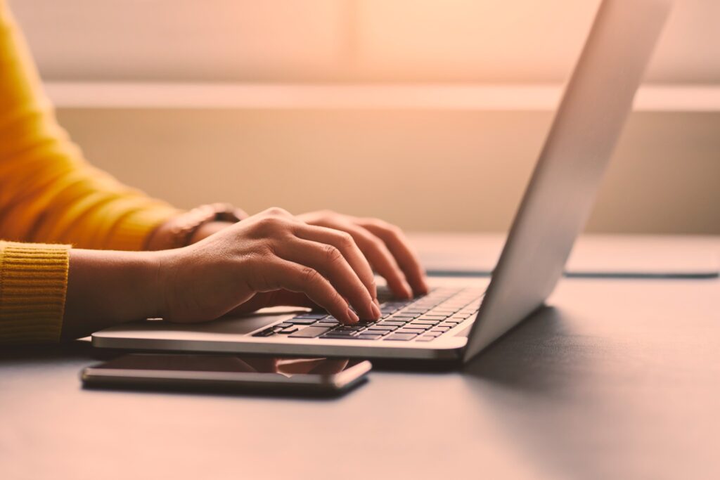 typing hands illustrating writing effective copy for your book's jacket or back cover